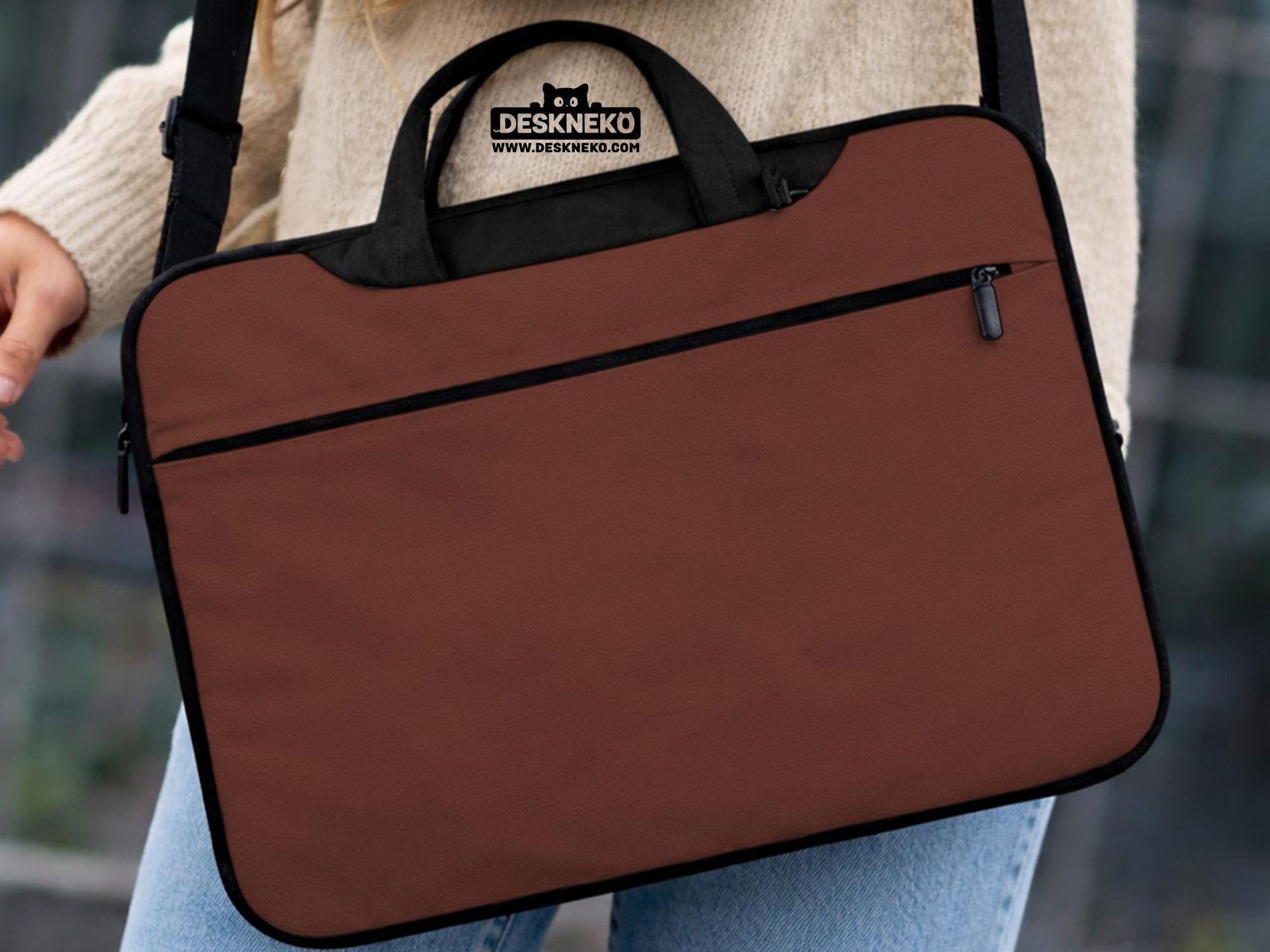 Brown laptop bag with a plain solid exterior, shown as a minimalist carrying case with handle and shoulder strap options.