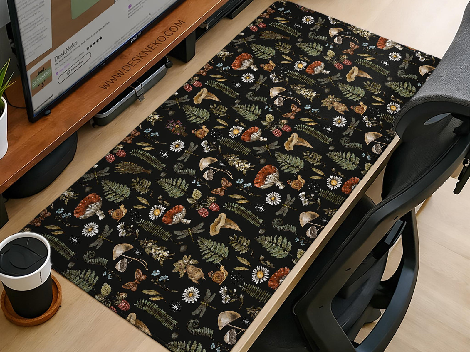 Black desk mat with a dark academia botanical pattern featuring mushrooms, insects, and forest foliage.