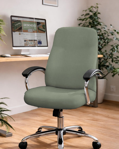 Sage green chair cover on an office chair in a modern desk setup with a simple, muted look.