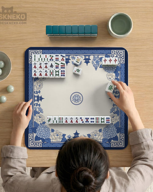 A square mahjong mat with a blue and white chinoiserie floral border and a plain center area.