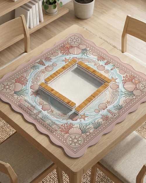 Blush pink mahjong table mat with seashells, coral branches, starfish, and soft seafoam wave details around the border.