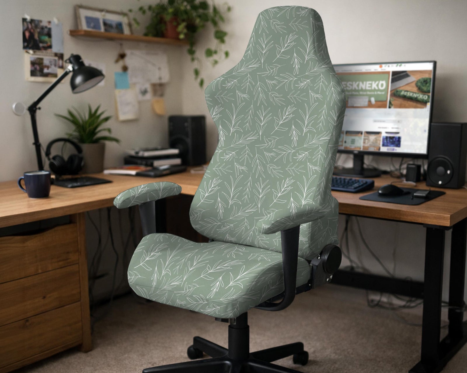 A gaming chair covered with a sage green botanical print stretch slipcover.