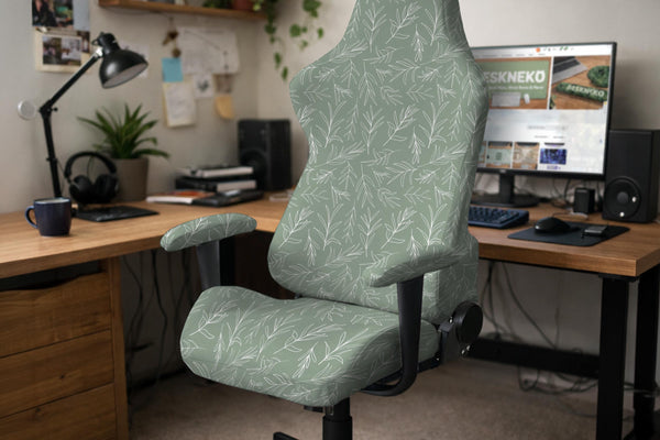 A gaming chair covered with a sage green botanical print stretch slipcover.