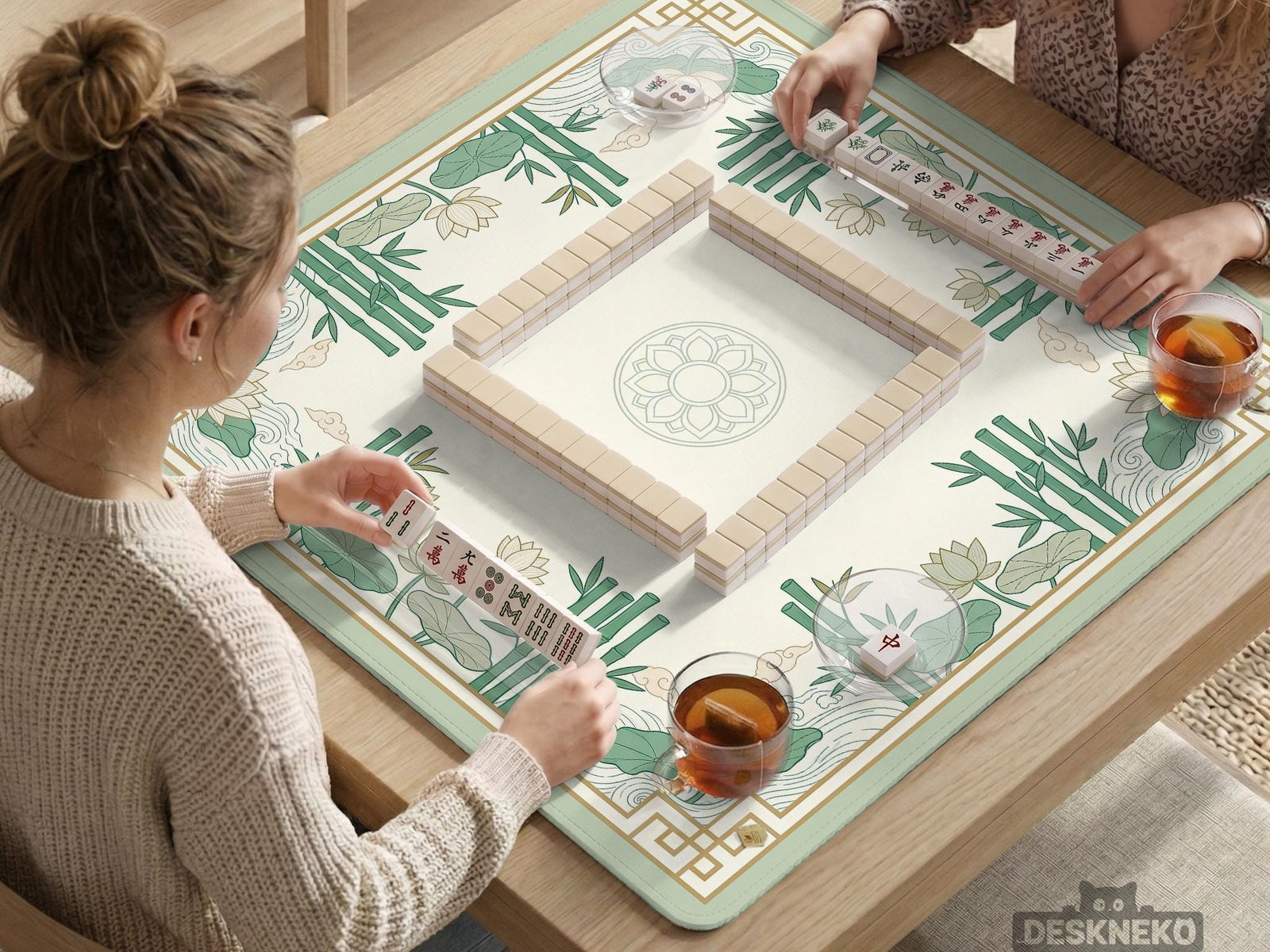 Sage green mahjong mat with bamboo leaves and lotus flowers printed across the surface.