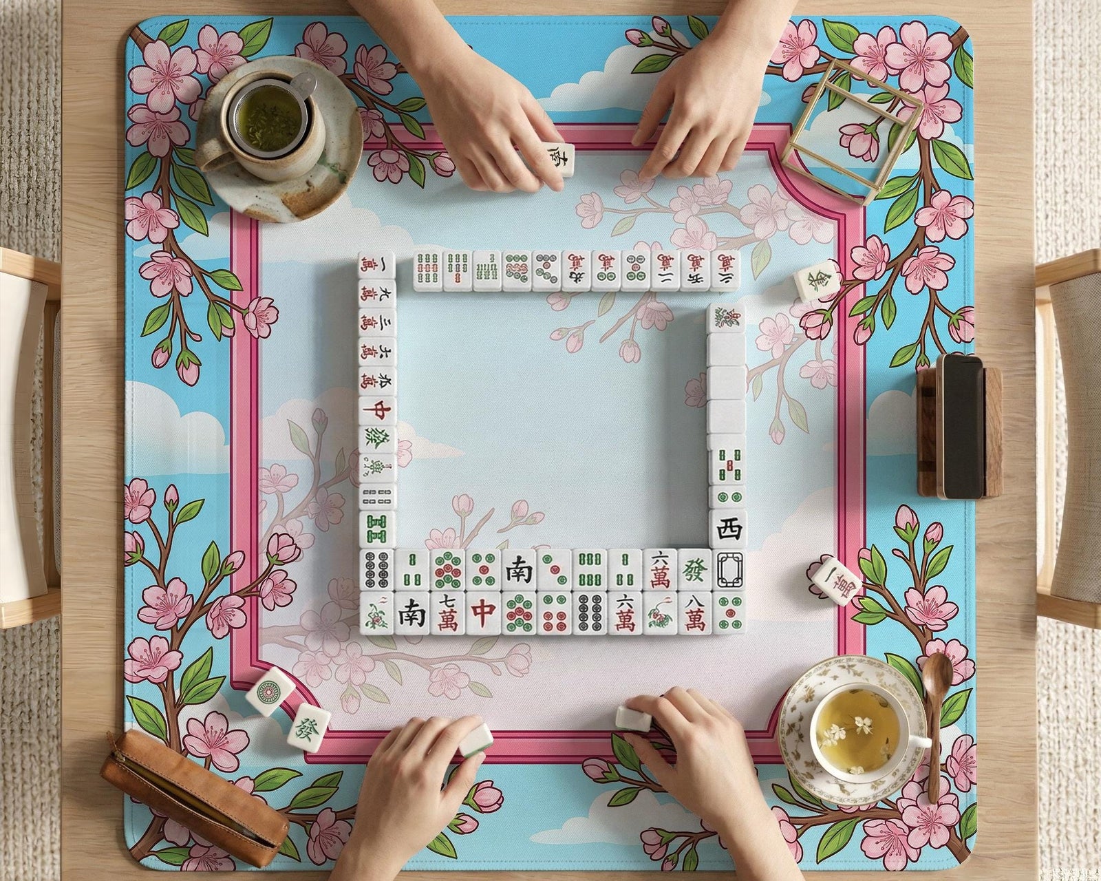Floral cherry blossom mahjong mat in pink and sky blue with sakura branches and cloud details around an open center area.