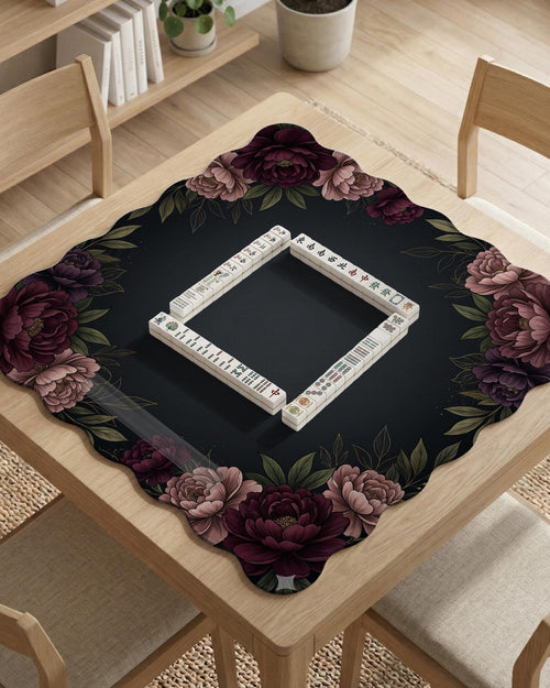 A floral mahjong mat with a dark background and peony border in burgundy, blush, olive, and cream tones.