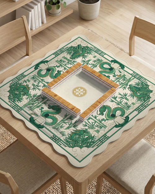 A square mahjong table mat with a green dragon and bamboo border on a cream background.