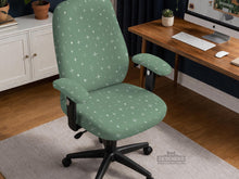 A sage green desk chair cover with a small white star pattern shown on a chair.