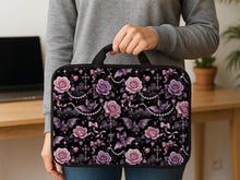 Pink laptop sleeve case with pastel goth print showing roses, small bats, bows, pearl chains, smoky clouds, and sparkle details.