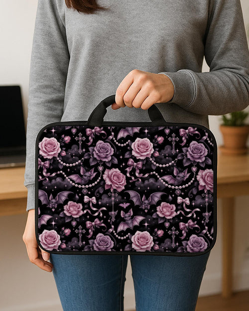 Pink laptop sleeve case with pastel goth print showing roses, small bats, bows, pearl chains, smoky clouds, and sparkle details.
