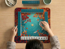 Square teal mahjong mat with a koi pond scene, orange koi fish, and autumn maple leaves around a decorative border.