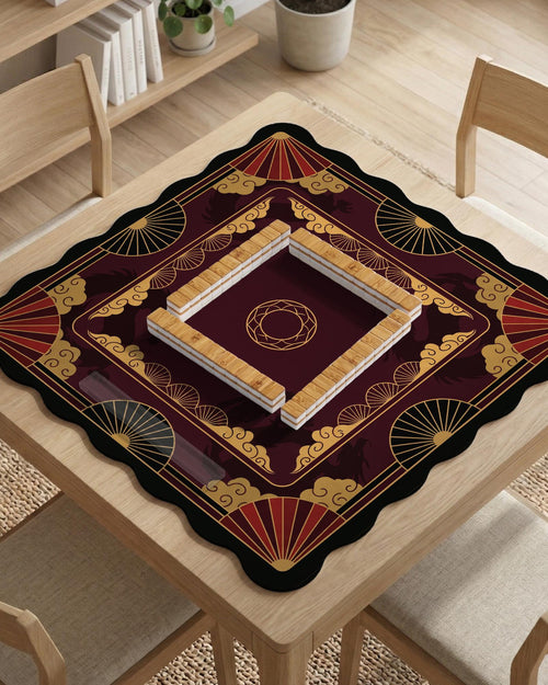 Square mahjong mat with red, black, and gold dragon silhouettes, cloud motifs, and decorative fan-like shapes.