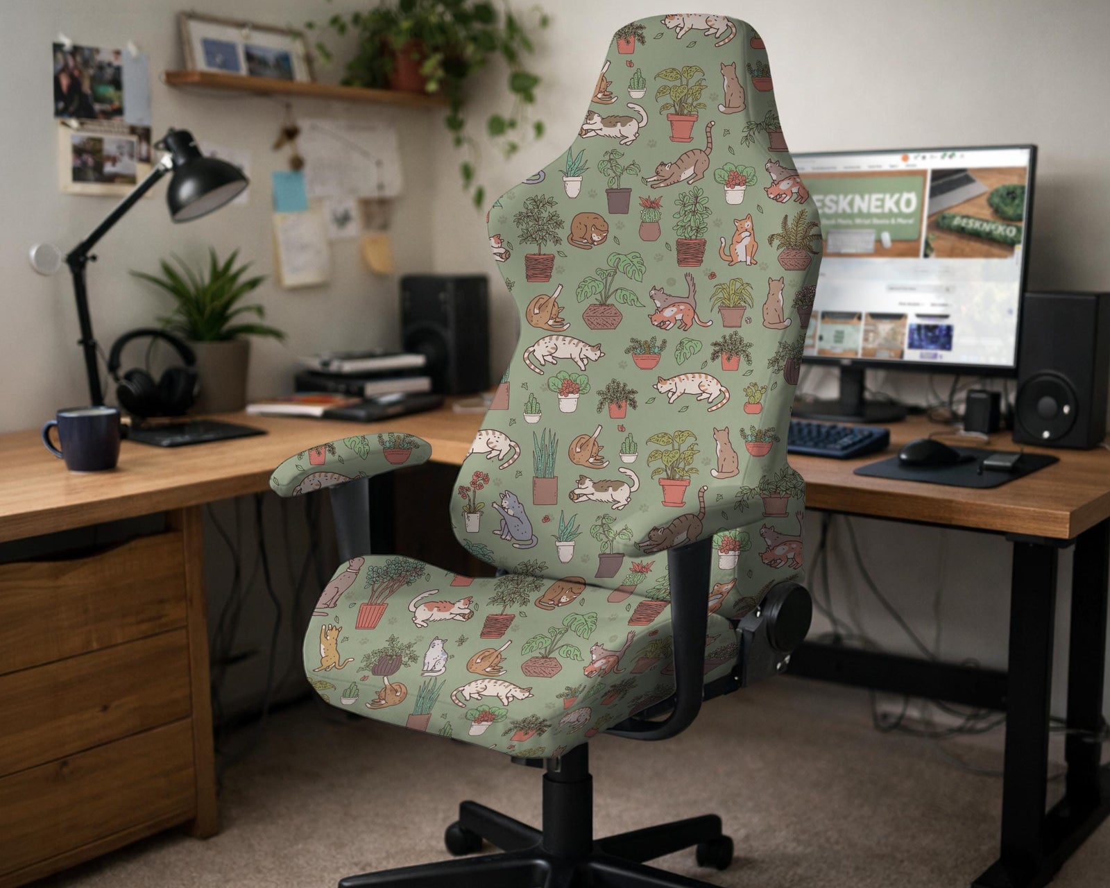 A sage green chair cover with a cat and houseplant print shown on an armrest office chair.