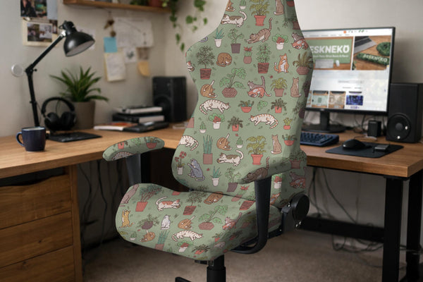 A sage green chair cover with a cat and houseplant print shown on an armrest office chair.