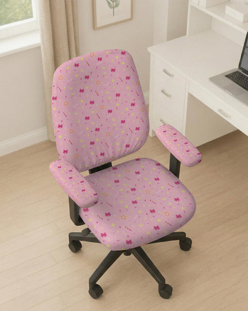 Pink chair cover with a pattern of moons, stars, bows, and small decorative shapes on a chair with armrests.