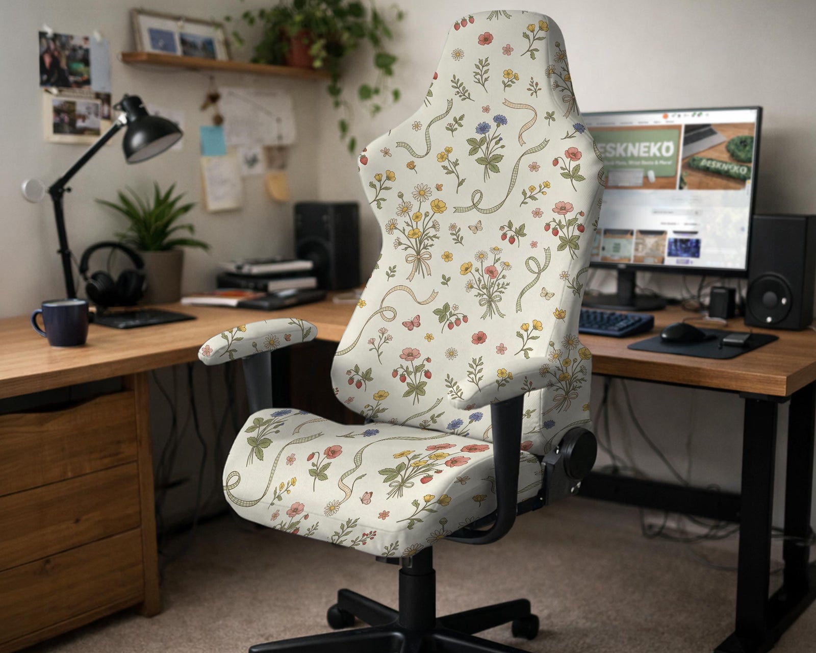 A chair cover with a creamy background and pastel meadow floral print shown on a high back office or gaming chair.