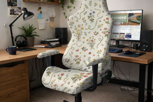 A chair cover with a creamy background and pastel meadow floral print shown on a high back office or gaming chair.