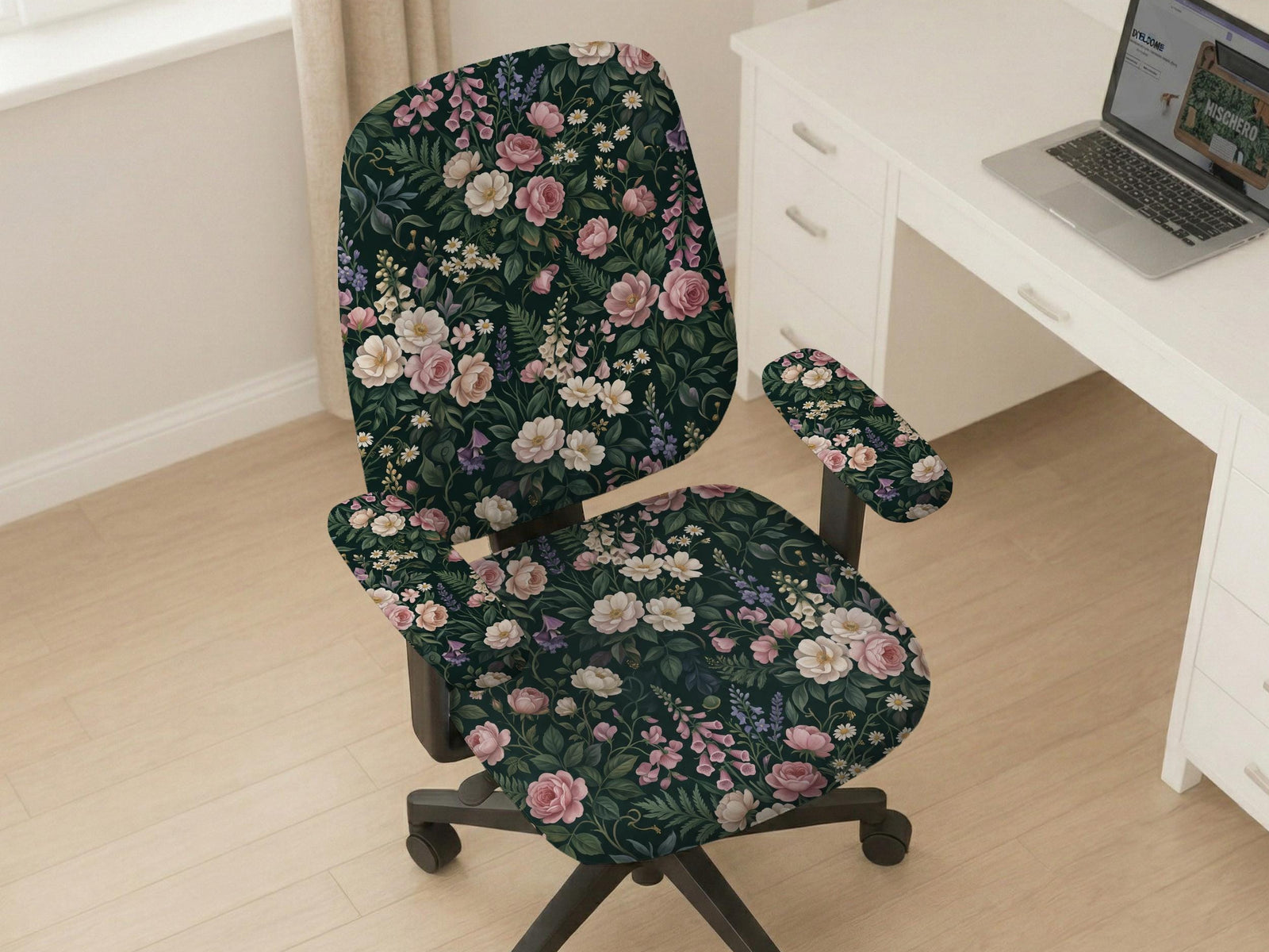 Green chair cover with a dark floral pattern, pink roses, cream flowers, and leafy botanical details on an office chair.