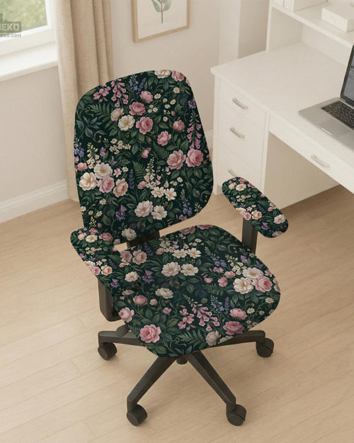 Green chair cover with a dark floral pattern, pink roses, cream flowers, and leafy botanical details on an office chair.