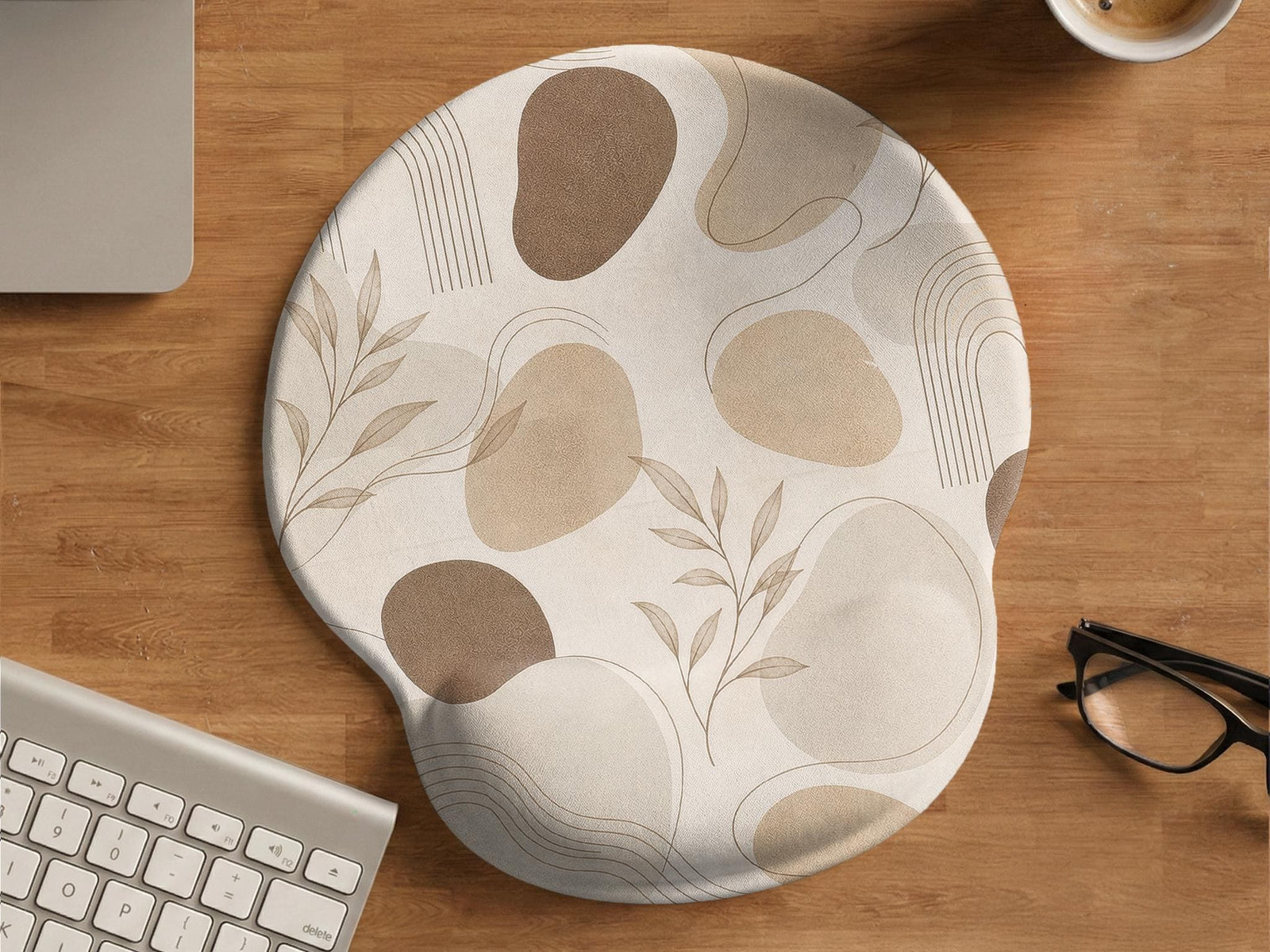 Beige ergonomic mouse pad with a neutral abstract botanical pattern and a raised wrist support area on one side.