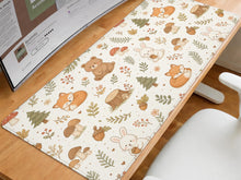 Cream desk mat with a woodland pattern of foxes, rabbits, mushrooms, acorns, berries, and leaves on a light background.