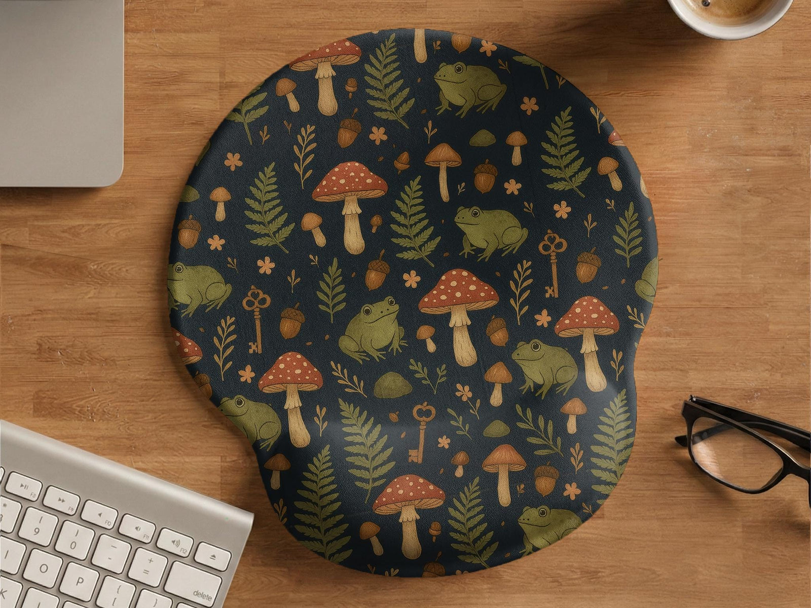 Mouse pad with a green frog, red mushrooms, fern leaves, tiny flowers, acorns, and old key details in a woodland pattern.