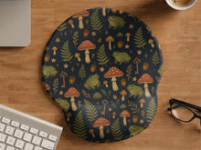 Mouse pad with a green frog, red mushrooms, fern leaves, tiny flowers, acorns, and old key details in a woodland pattern.