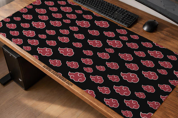A black desk mat with a red cloud pattern shown on a computer desk with a keyboard and mouse.