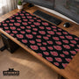 A black desk mat with a red cloud pattern shown on a computer desk with a keyboard and mouse.
