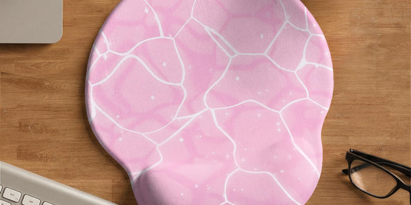 Soft pink mouse pad and wrist rest with a cloud-marble pattern, pale linework, and small star details.