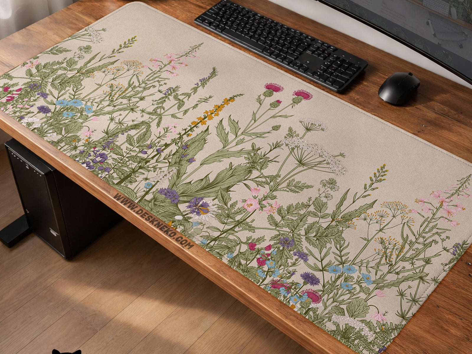 A desk mat with a botanical meadow design featuring wildflowers, leafy stems, and soft neutral colors.