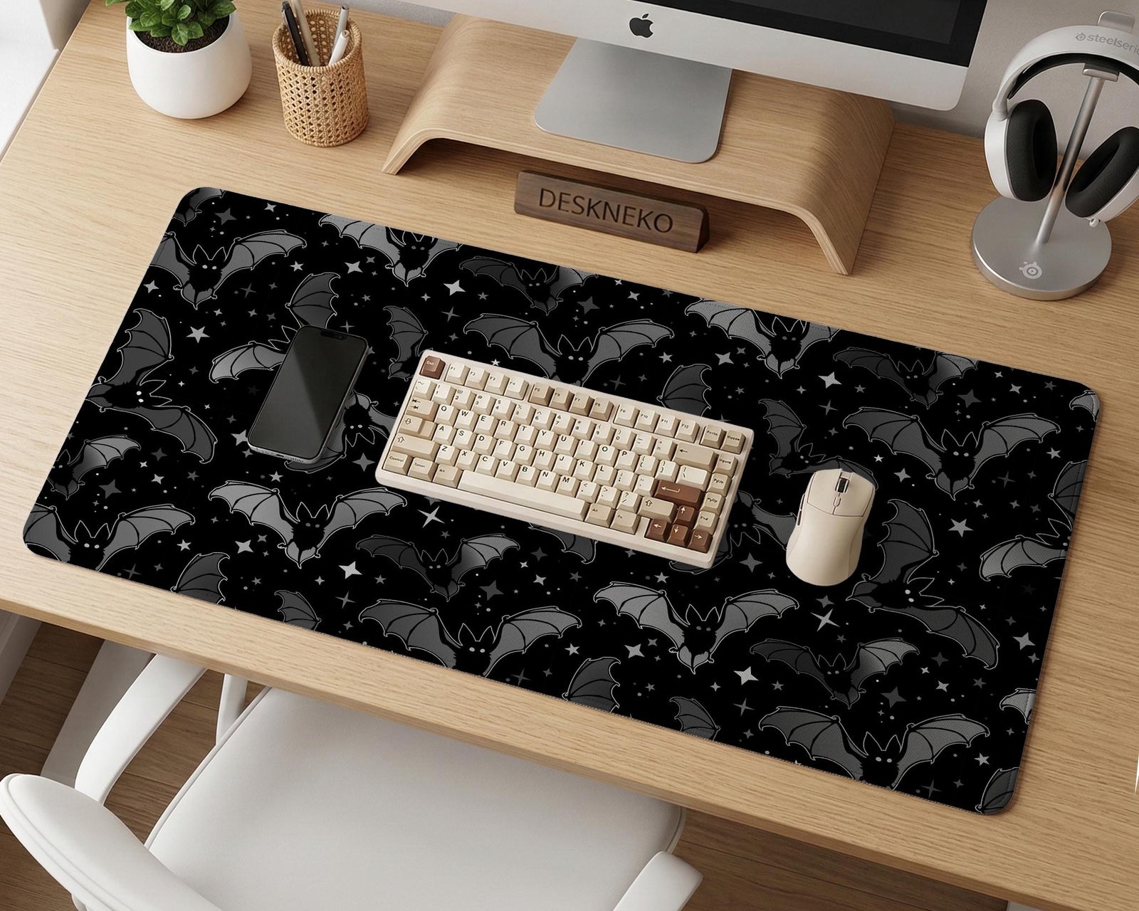 Black desk mat with a dark bat pattern and scattered stars on a charcoal background.