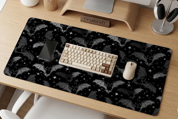Black desk mat with a dark bat pattern and scattered stars on a charcoal background.