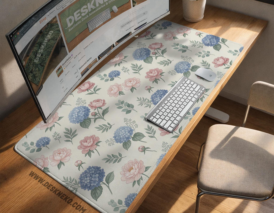Floral desk mat with sage greenery, pink peonies, blue flowers, and a warm cream background.