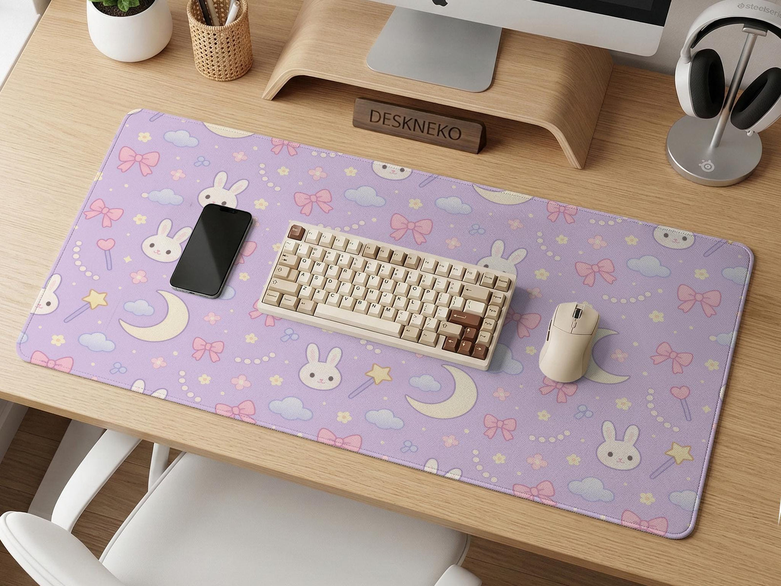 Pastel lavender desk mat with an all-over pattern of bunnies, crescent moons, clouds, bows, stars, and small flowers.