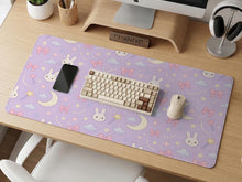 Pastel lavender desk mat with an all-over pattern of bunnies, crescent moons, clouds, bows, stars, and small flowers.