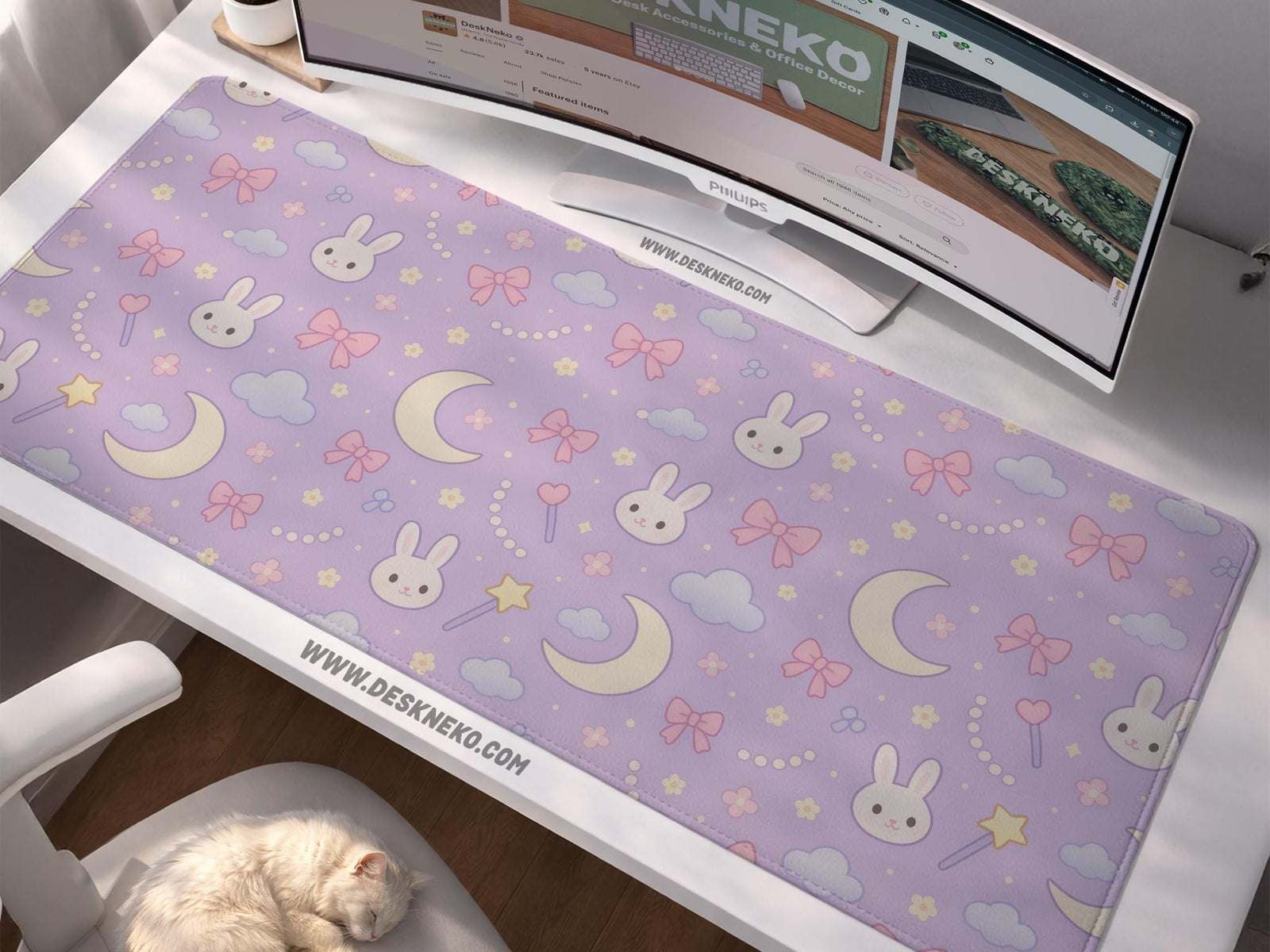Lavender desk mat with an all-over pattern of bunny faces, clouds, moons, bows, and flowers in pastel colors.