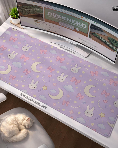 Lavender desk mat with an all-over pattern of bunny faces, clouds, moons, bows, and flowers in pastel colors.
