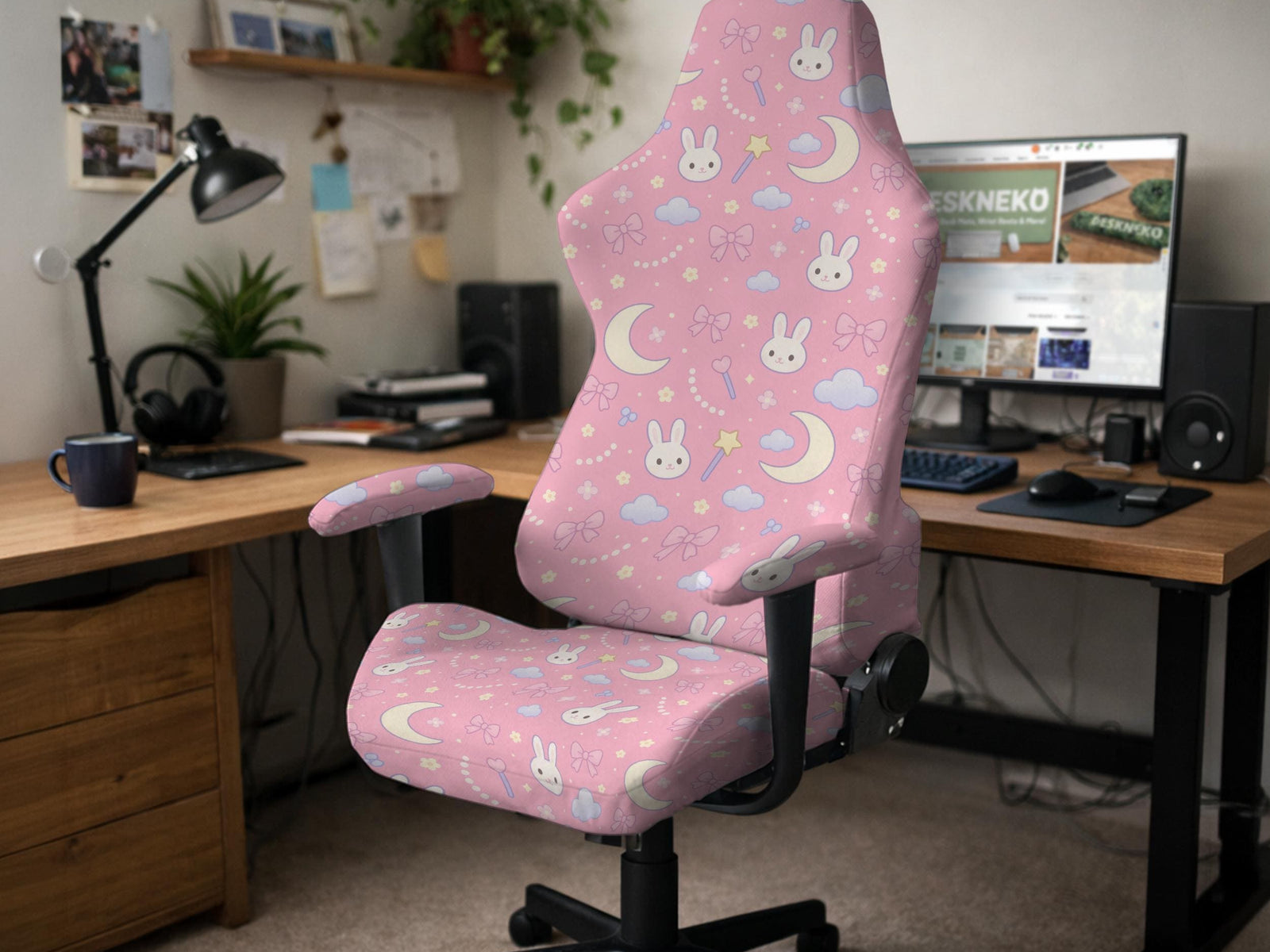 Pink chair cover with bunny faces, crescent moons, clouds, and bows on a white chair.