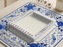Square blue and white mahjong mat with peonies, cranes, pagoda accents, and chinoiserie linework around a plain center.