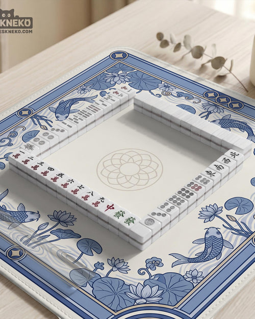 Blue and white mahjong table mat with koi fish, lotus flowers, lily pads, and a decorative border around an open center.