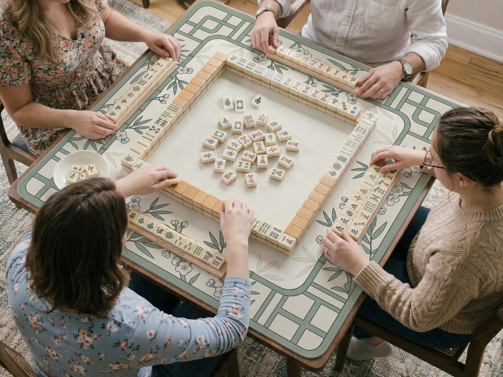Square mahjong mat with a sage green bamboo floral line design, cream background, and rounded border.