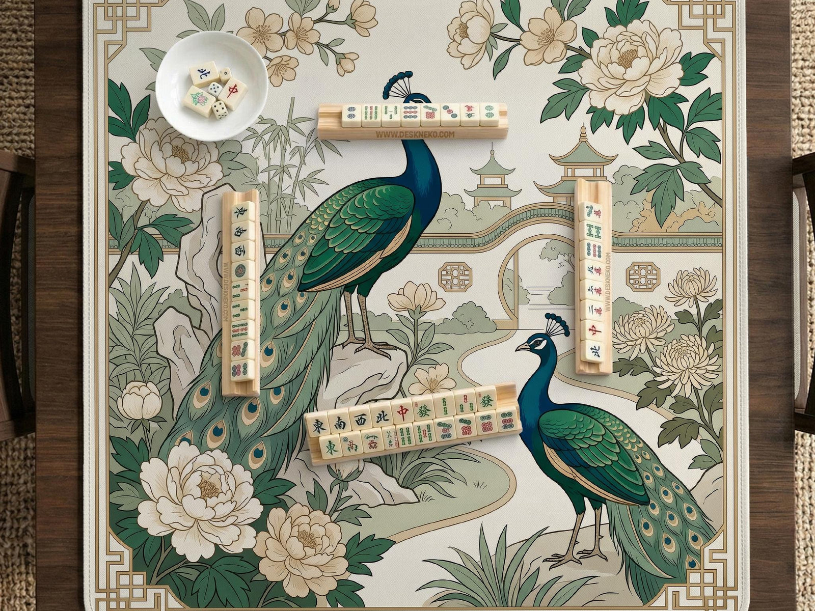 An ivory mahjong mat with a peacock garden design, green botanicals, cream peonies, bamboo leaves, pagoda details, and geometric corner borders.