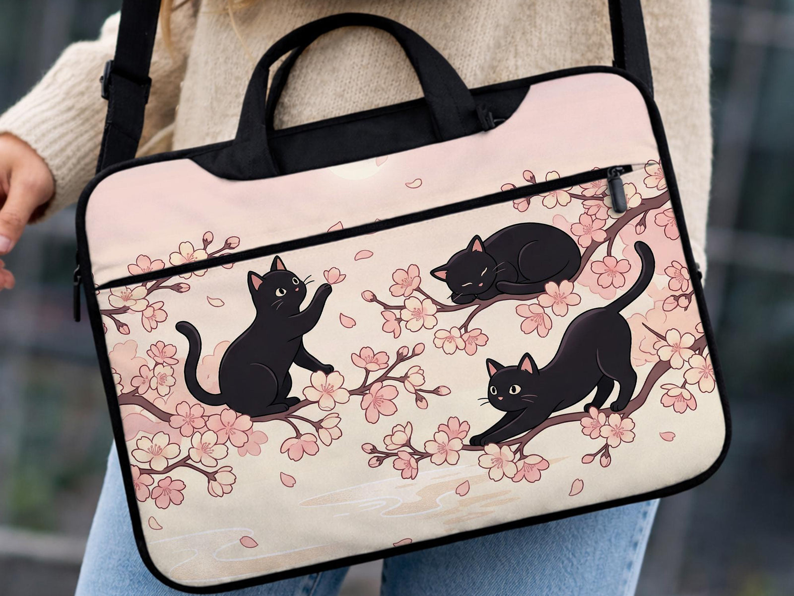 Black laptop bag and sleeve with a sakura and black cat print, shown with handle and shoulder strap options and multiple size selections.