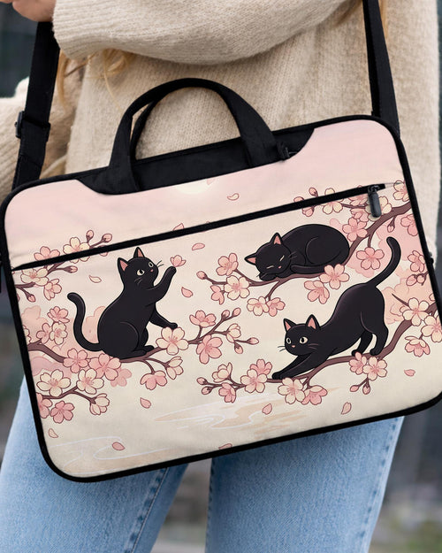 Black laptop bag and sleeve with a sakura and black cat print, shown with handle and shoulder strap options and multiple size selections.