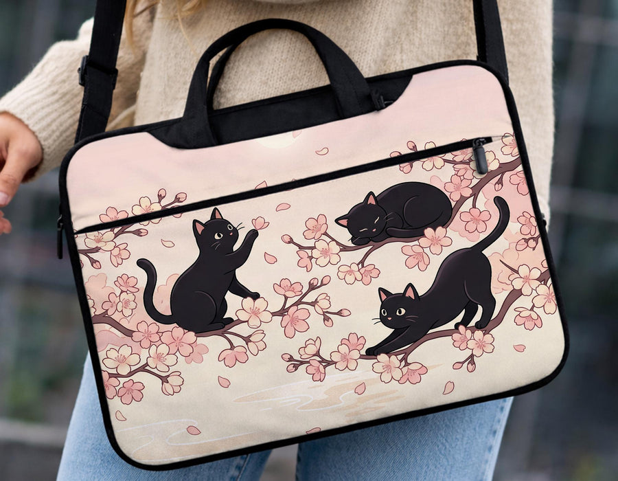 Black laptop bag and sleeve with a sakura and black cat print, shown with handle and shoulder strap options and multiple size selections.