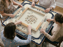 Navy and cream square mahjong mat with cranes, bamboo, clouds, and floral corner details around a plain center area.