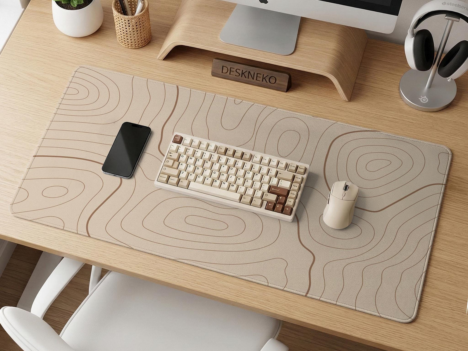 Beige desk mat with soft brown topographic contour lines on a neutral background.