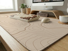A beige mousepad with a topographic line pattern in a repeating design.