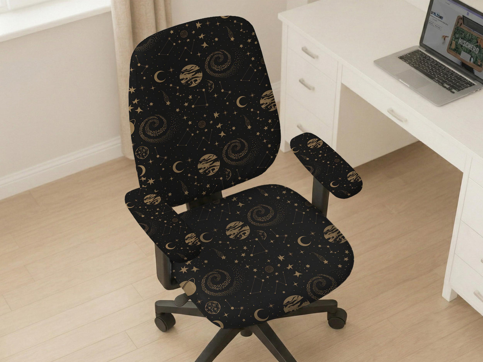 Black chair cover with a dark galaxy pattern, muted gold stars and celestial artwork on a chair.